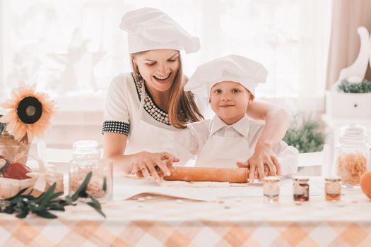 happy mom and little son are cooking together . the concept of parenting