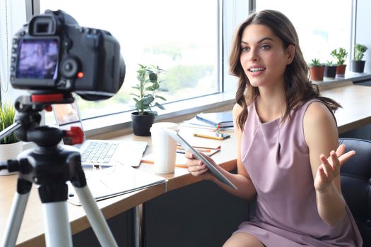 Beautiful young woman talking and smiling while making new video for her blog