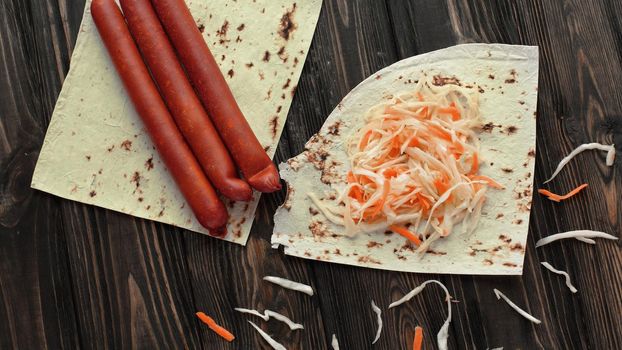 delicate sausages ,cabbage and pita bread on wooden background.