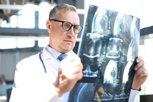 Doctor therapist looking closely at the x-ray