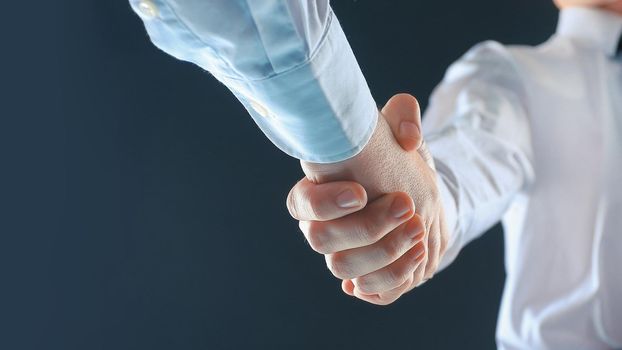 close up. businessman shaking hands with business partner.isolated on black background