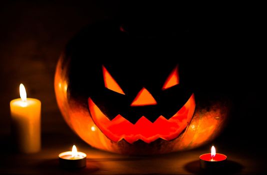 candles and pumpkin for Halloween in a cramped room.photo with copy space.
