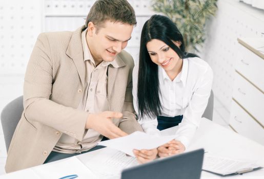 two members of the company discussing marketing schemes,sitting at their Desk