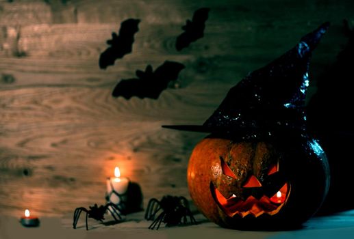 creepy pumpkin for Halloween in witch hat on wooden background .happy Halloween concept