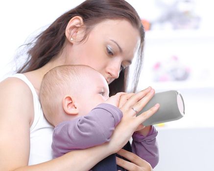 caring young mother feeds the baby.