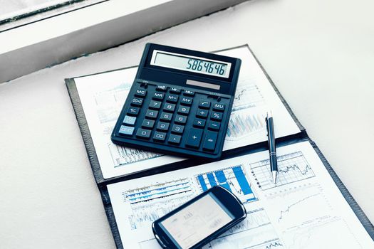 calculator, smartphone and financial documents on the businessman's Desk. business concept