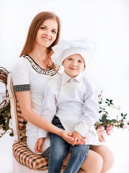 portrait of mom and her little son in a chef's suit sitting together