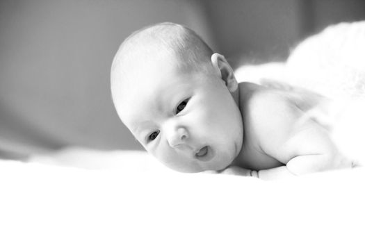 pretty newborn girl lying on her tummy on a blanket. photo with copy space