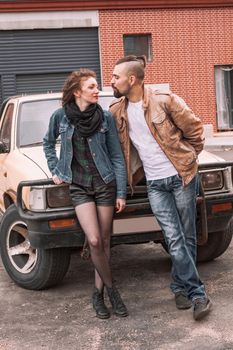 young couple standing near the car in the city Parking lot . the concept of love and relationships