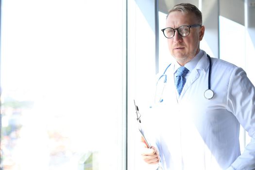 Senior chief physician in white robe with stethoscope