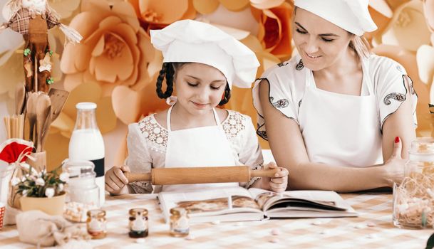 mother and daughter playing in the chefs and cooks dinner in the kitchen