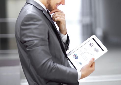 businessman looks at digital tablet screen with the digital schedule.