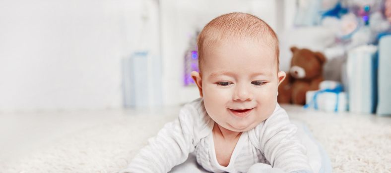 pretty baby lying on the carpet in the living room cozy . the concept of Christmas