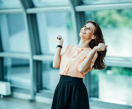 enthusiastic business woman rejoices achievements in business. the photo has a empty space for your text