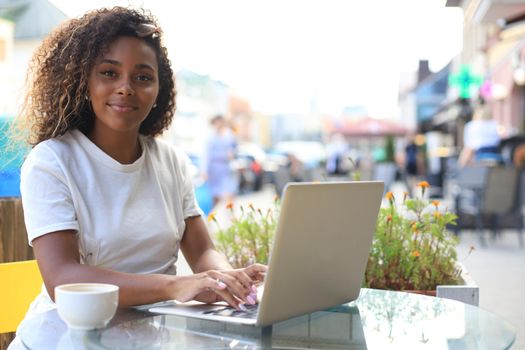 Attractive woman using laptop in cafe. Concept of entrepreneur, businesswoman, freelance worker