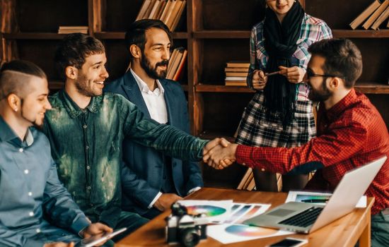 advertising Manager with a handshake greets the customer in a modern office