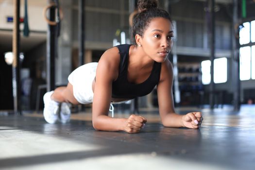 Portrait of a muscular woman on a plank position