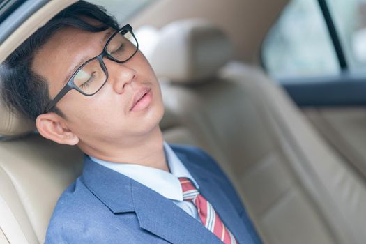 Young asian business men portrait in suit sit in the backseat of a car