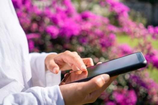 Woman hand using smartphone to do work business, social network, communication in public cafe work space area.