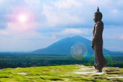 Buddha looking seven day style and sun back cloud over mountain background, Makha Bucha Day is held full moon day on february or march
