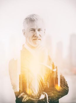 Double exposure of senior businessman in front of the big city