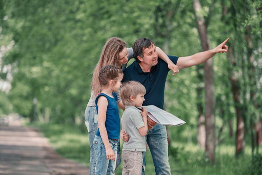 family with children discussing the route of travel on the map . family holiday concept