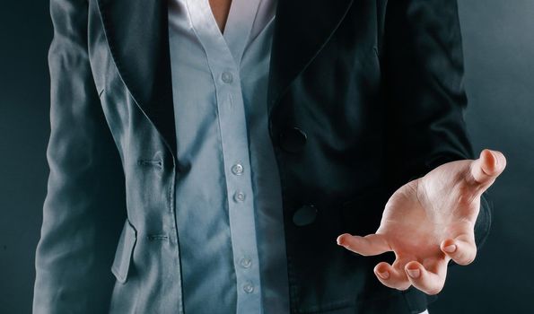 close up. business woman holding a virtual ball.isolated on black background.
