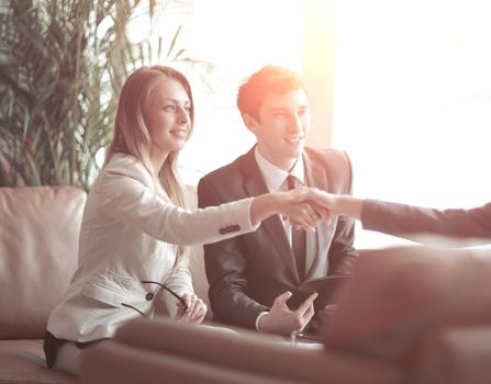 two business women hold each other by the hands,sitting at the Desk. concept of partnership