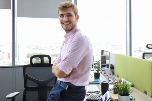 Portrait of young man sitting at his desk in the office