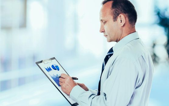 closeup -investor studies the financial schedule of revenues of the company.photo blurred background and has an empty space for your text