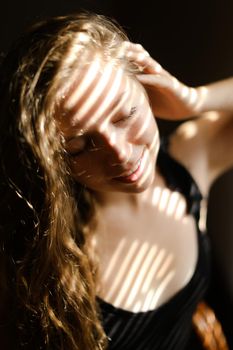 Close up portrait of young girl with striped shadows. Concept of private photo session and beautiful femaleperson with eveday makeup.