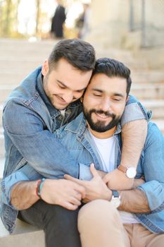 Caucasian young gays hugging and wearing jeans shirts. Concept of same sex couple and relationship.