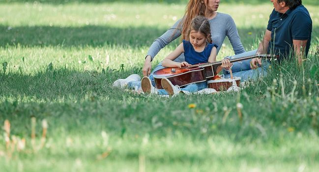 parents with small two children on the lawn on a spring day. good time
