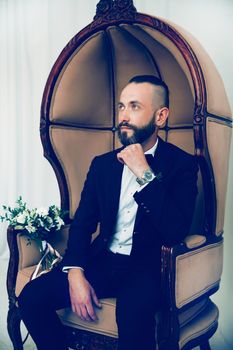 close up. serious groom waiting for his bride sitting in a chair . people and events