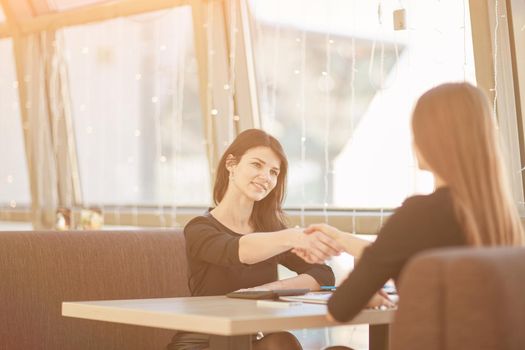 two business women shaking hands at an informal meeting. concept of cooperation