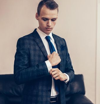 successful young businessman adjusting his cufflinks. business concept