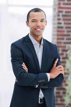 smiling young businessman on background of office.photo with copy space