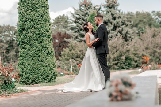 loving couple of newlyweds standing in city Park. holidays and events