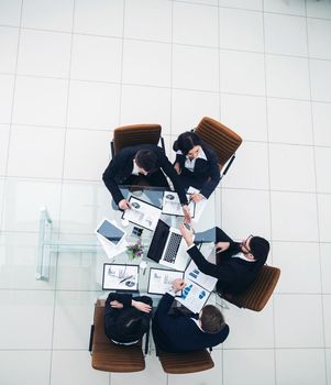 top view of successful business team discussing marketing schemes and financial schedules for the development of the company.the photo is a blank space for your text