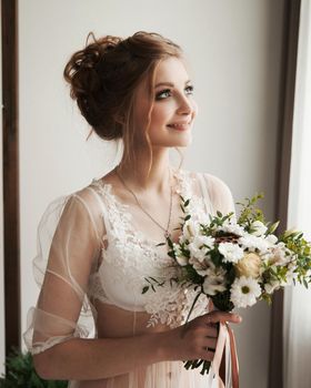 close up. happy young woman with bouquet on her wedding day. Bride's boudoir in the morning.