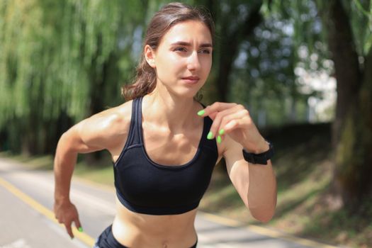 Young woman in sports clothing running while exercising outdoors