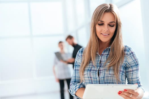 young businesswoman uses a digital tablet standing in the office. photo with copy space