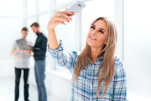 young businesswoman takes a selfie standing in the office . photo with copy space