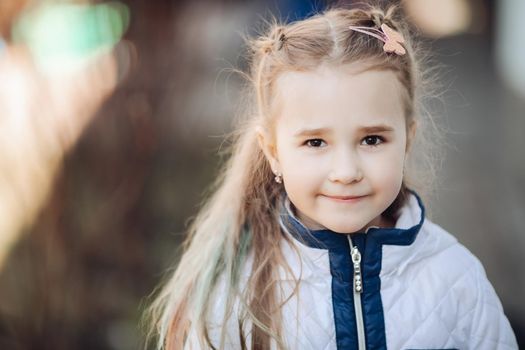 Attractive female caucasian child looks to the camera with blur background