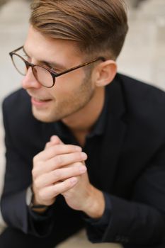 Closeup portrait of handsome male person wearing black suit and glasses. Concept of fashionable model.