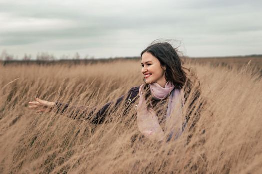 pretty young woman walking on a wheat field. photo with copy space