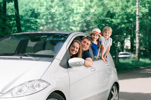 happy family with children sitting in a family car. travel together