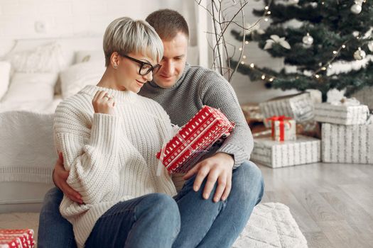 Family at home. Couple near christmas decorations. Woman in a gray sweater.