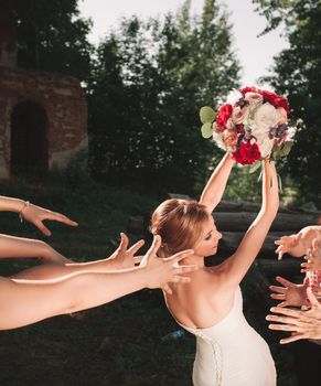 smiling bride tossing a bouquet for her good friends. holidays and traditions