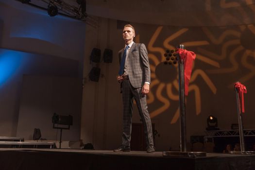 stylish male model standing on the catwalk during a fashion show